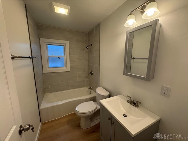 full bathroom featuring hardwood / wood-style flooring, vanity, toilet, and tiled shower / bath