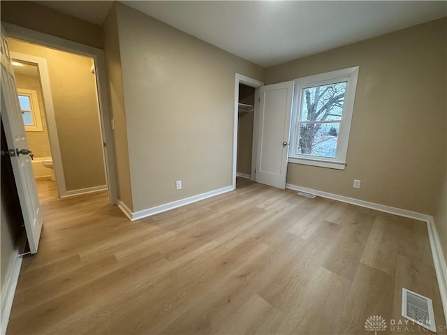 unfurnished bedroom featuring a closet and light wood-type flooring