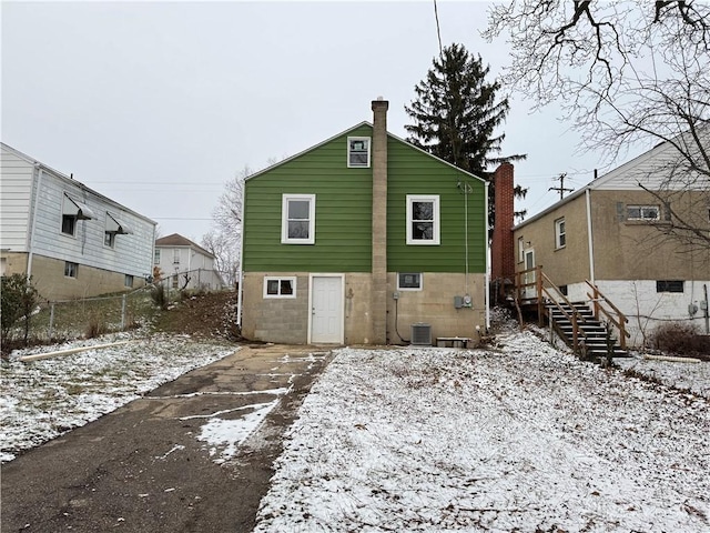 snow covered property with central AC