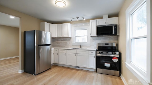 kitchen featuring white cabinetry, stainless steel appliances, sink, and tasteful backsplash