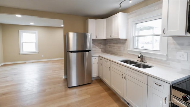 kitchen featuring sink, stainless steel appliances, white cabinets, and light wood-type flooring