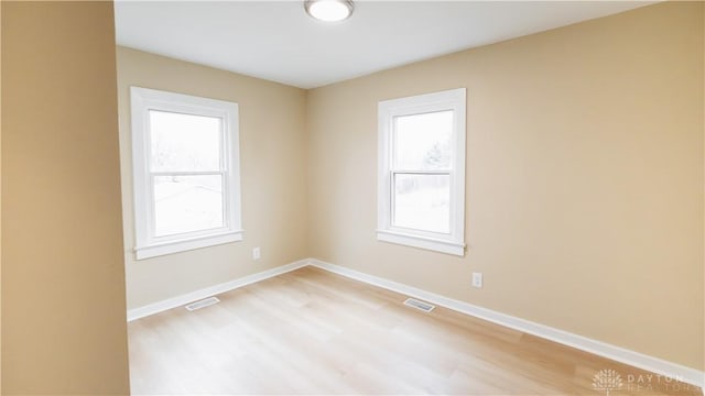 unfurnished room featuring plenty of natural light and light wood-type flooring