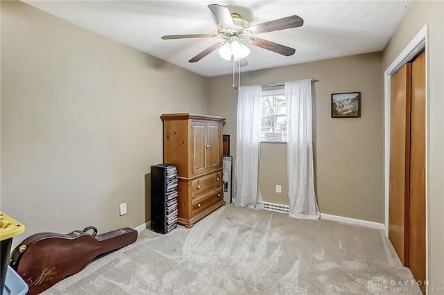 carpeted bedroom featuring ceiling fan and a closet