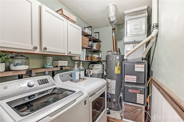 washroom with water heater, washer and clothes dryer, and cabinets