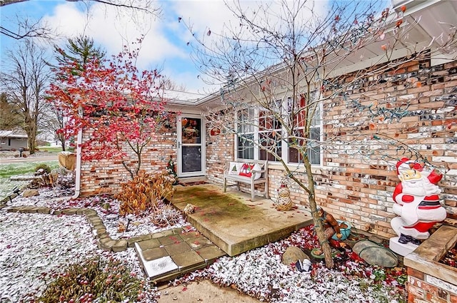 view of snow covered exterior with a patio