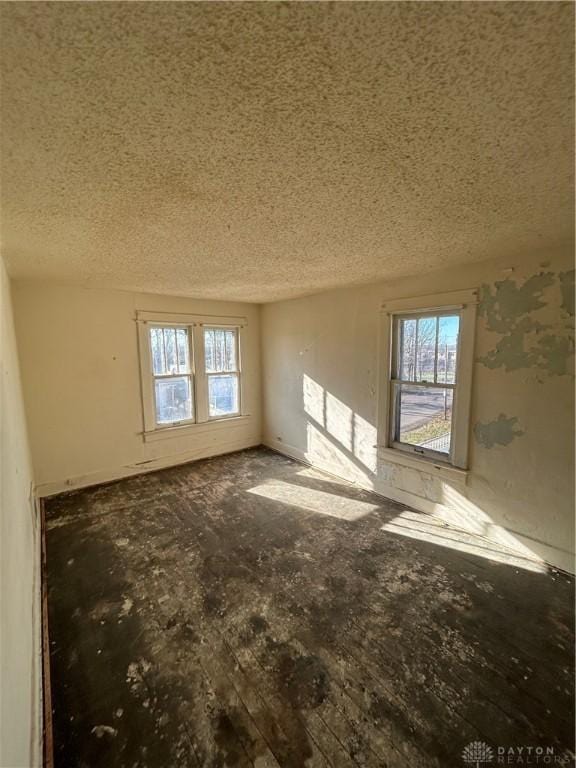 empty room featuring a textured ceiling and a wealth of natural light