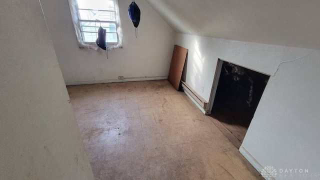 additional living space with vaulted ceiling and a baseboard heating unit