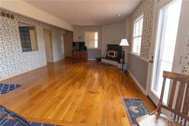 unfurnished living room featuring hardwood / wood-style floors and a wood stove