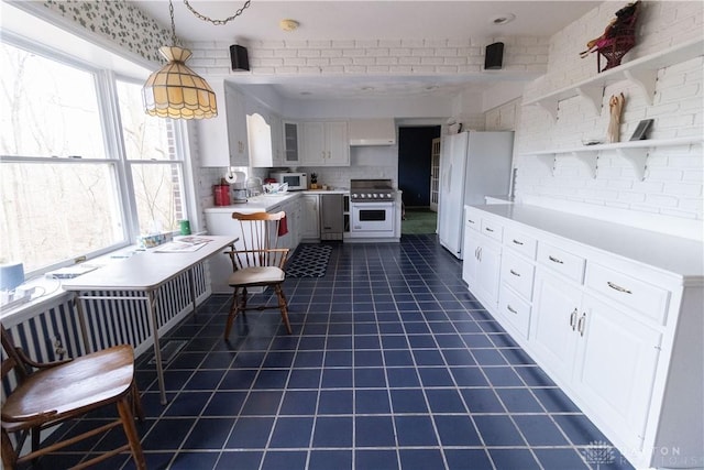 kitchen with plenty of natural light, white cabinets, decorative light fixtures, and white appliances