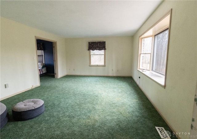 carpeted spare room featuring a healthy amount of sunlight