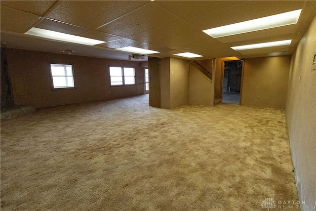 basement featuring a paneled ceiling and carpet