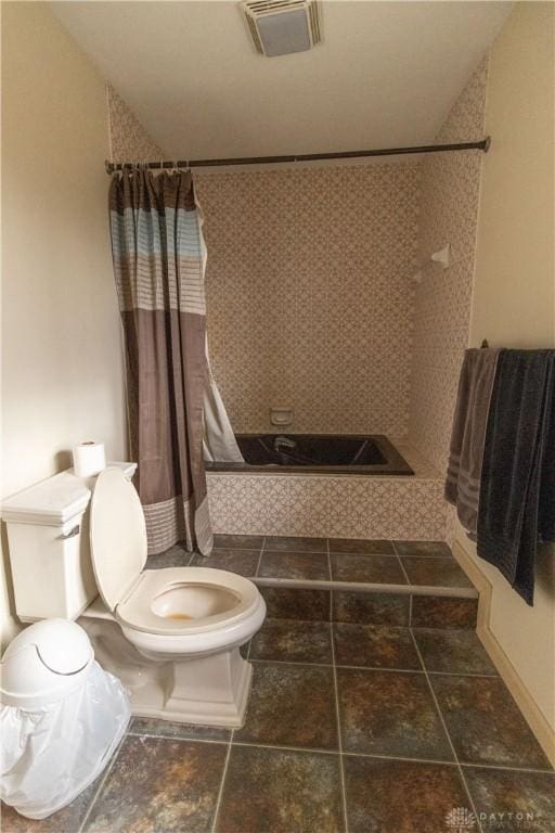 bathroom with shower / tub combo and toilet