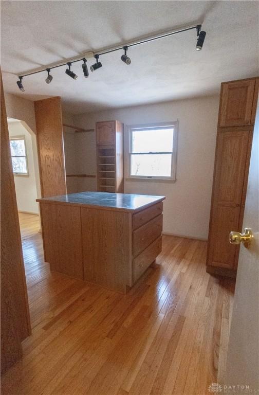 kitchen with a center island, rail lighting, plenty of natural light, and light hardwood / wood-style flooring