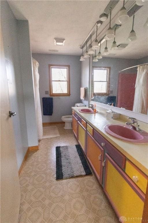 bathroom featuring curtained shower, vanity, and toilet