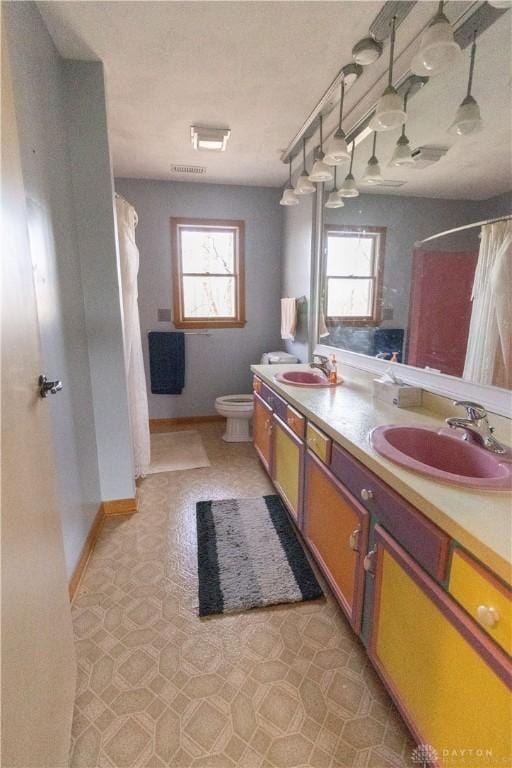 bathroom with walk in shower, vanity, and toilet