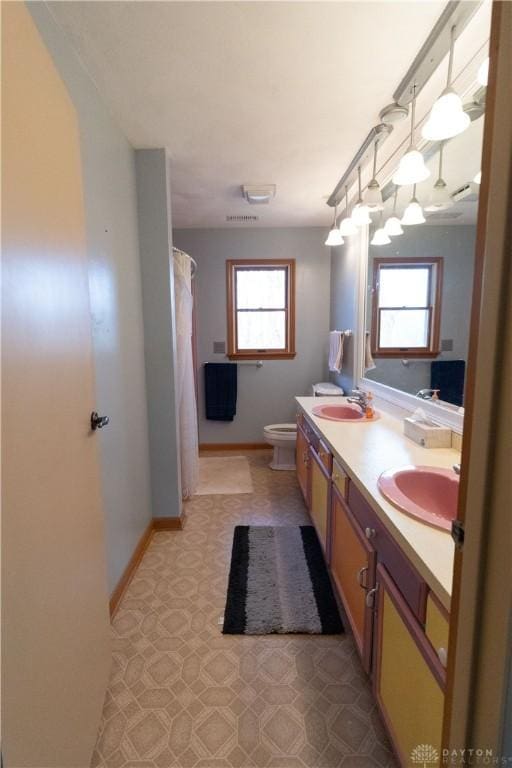 bathroom featuring plenty of natural light, vanity, and toilet