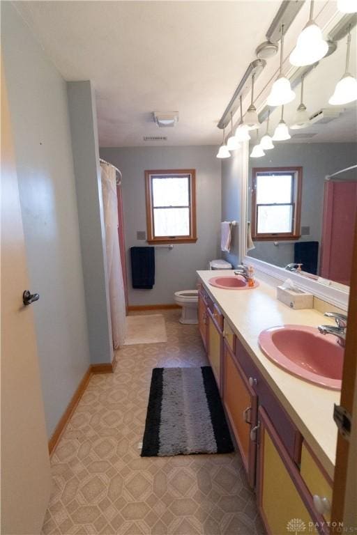 bathroom with vanity, a healthy amount of sunlight, and toilet