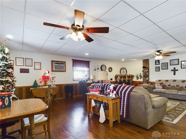 living room featuring dark hardwood / wood-style flooring, a drop ceiling, and ceiling fan