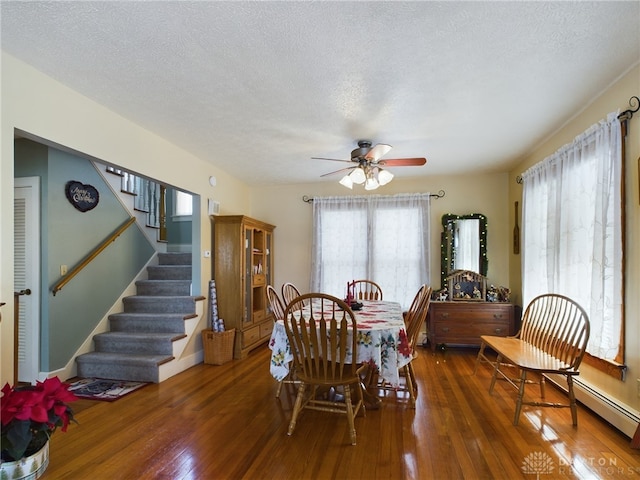 dining area with a textured ceiling, ceiling fan, and dark wood-type flooring