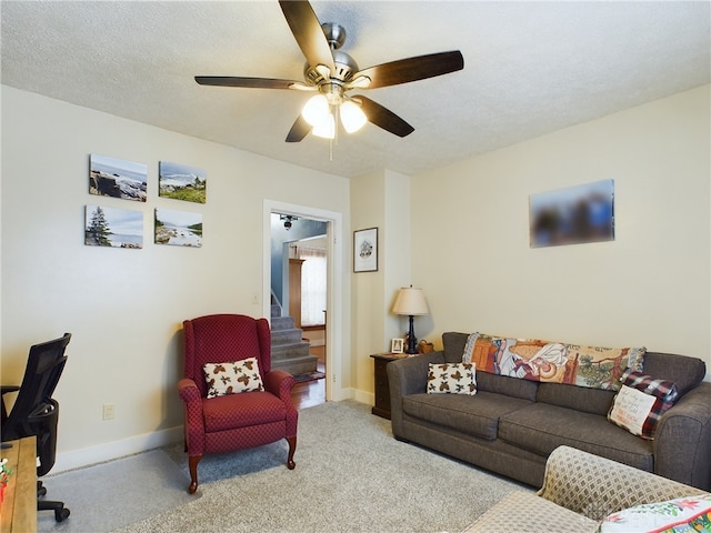 living room with ceiling fan, light colored carpet, and a textured ceiling