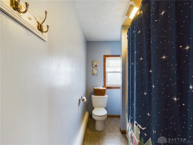 bathroom featuring tile patterned floors, a textured ceiling, and toilet