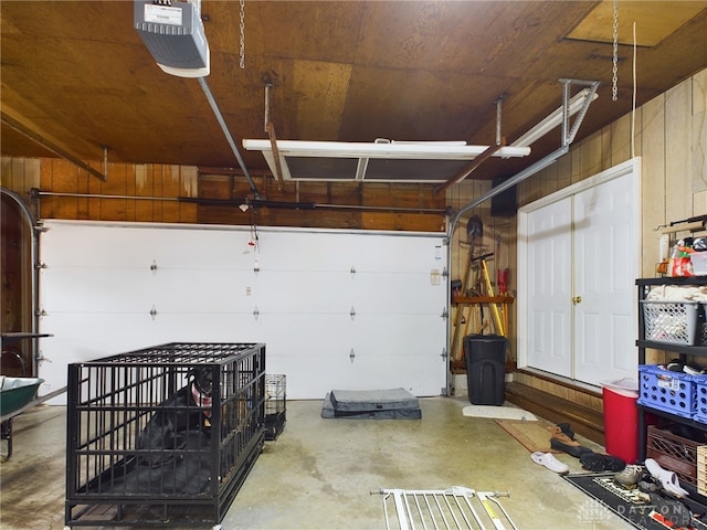 garage featuring wood walls and a garage door opener