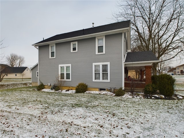 view of snow covered back of property