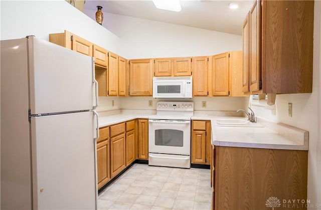 kitchen featuring vaulted ceiling, sink, and white appliances