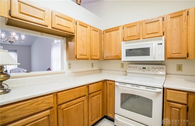 kitchen featuring white appliances and an inviting chandelier