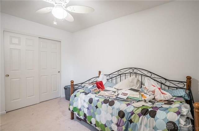 carpeted bedroom with ceiling fan and a closet