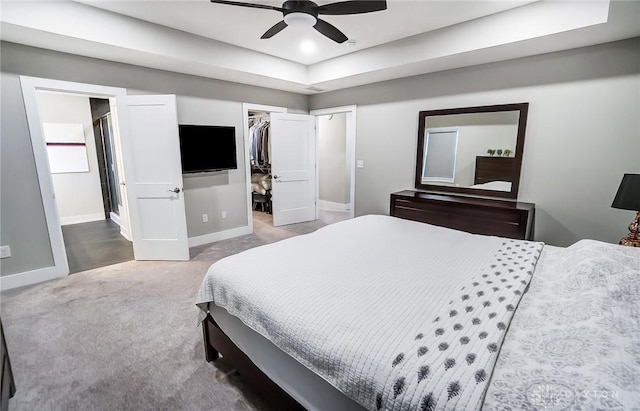 carpeted bedroom featuring a closet, a spacious closet, and ceiling fan