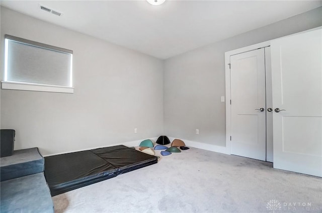 exercise room with light colored carpet