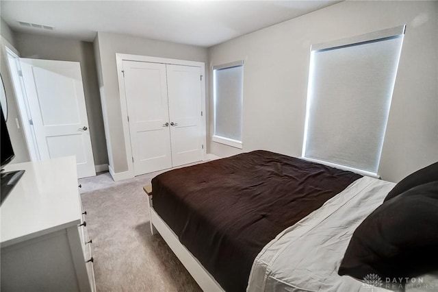 bedroom with light carpet and a closet