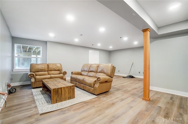 living room featuring ornate columns and light hardwood / wood-style flooring