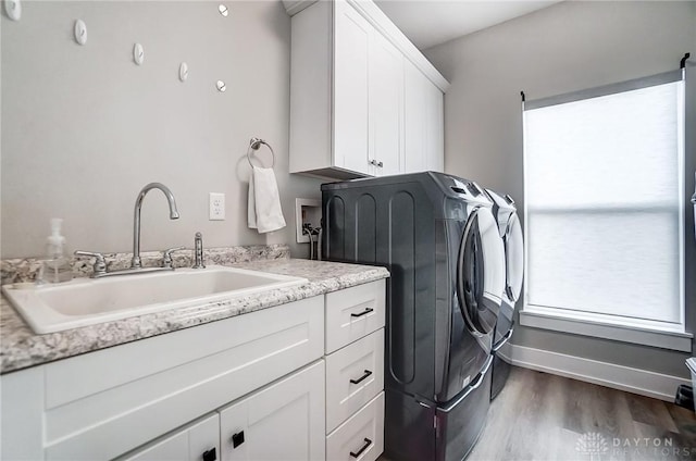 laundry room featuring washer and clothes dryer, sink, cabinets, and dark hardwood / wood-style floors