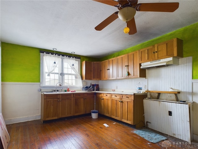 kitchen with brown cabinetry, light countertops, and a sink