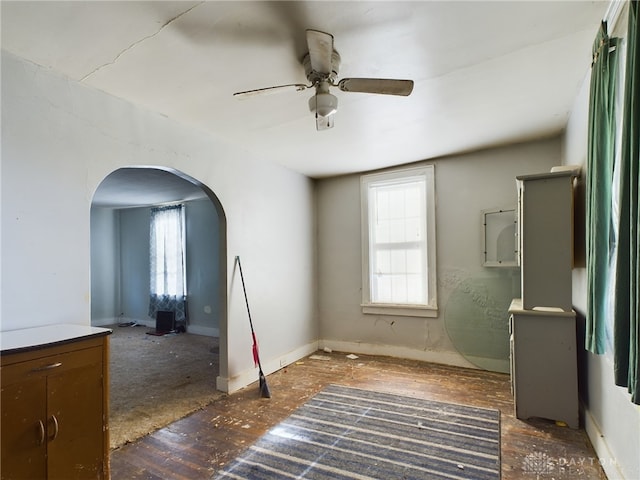 unfurnished room with arched walkways and ceiling fan