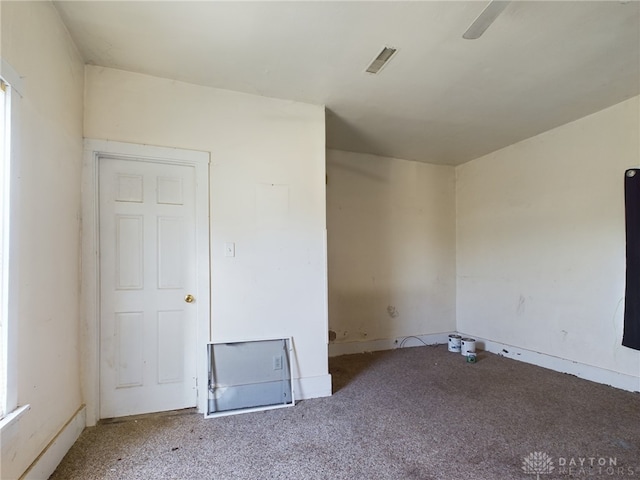 empty room with carpet floors and visible vents