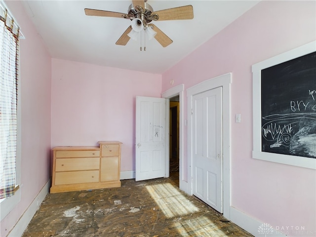 unfurnished bedroom with ceiling fan and baseboards