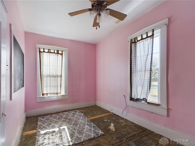 spare room with ceiling fan and baseboards