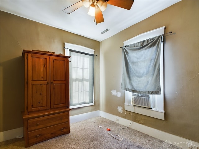 unfurnished bedroom with light colored carpet, visible vents, a ceiling fan, cooling unit, and baseboards