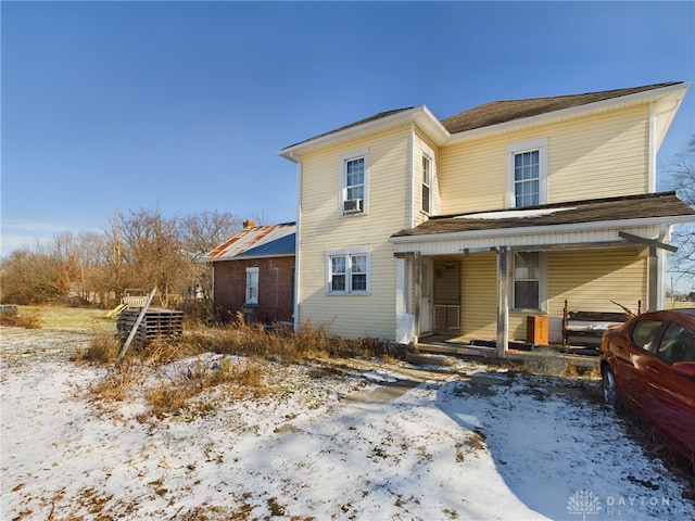 snow covered property with a porch