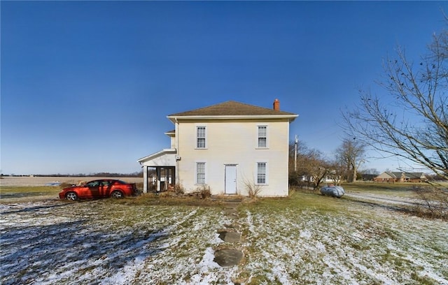 snow covered property with a chimney