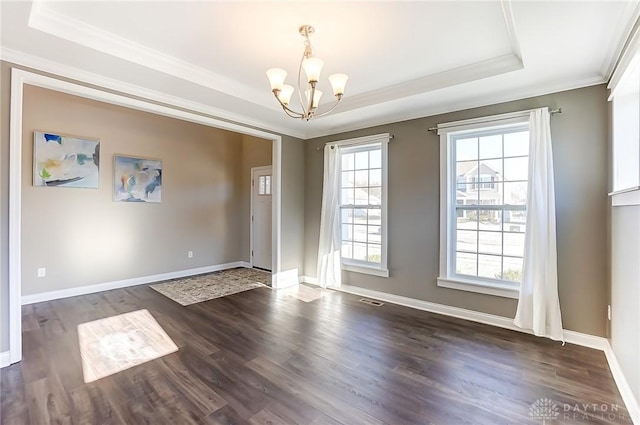 interior space featuring a raised ceiling, a notable chandelier, dark hardwood / wood-style flooring, and ornamental molding