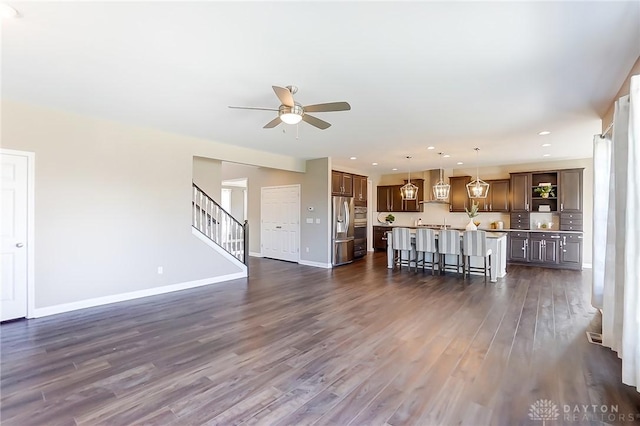 unfurnished living room with ceiling fan and dark hardwood / wood-style flooring