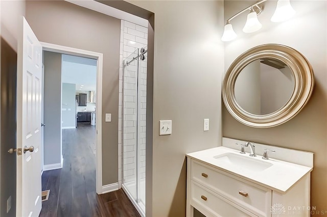 bathroom featuring hardwood / wood-style floors, vanity, and walk in shower