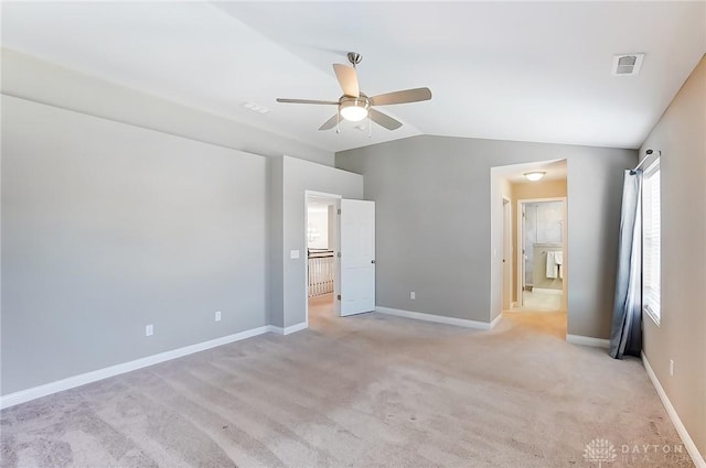 unfurnished bedroom featuring light colored carpet, vaulted ceiling, and ceiling fan