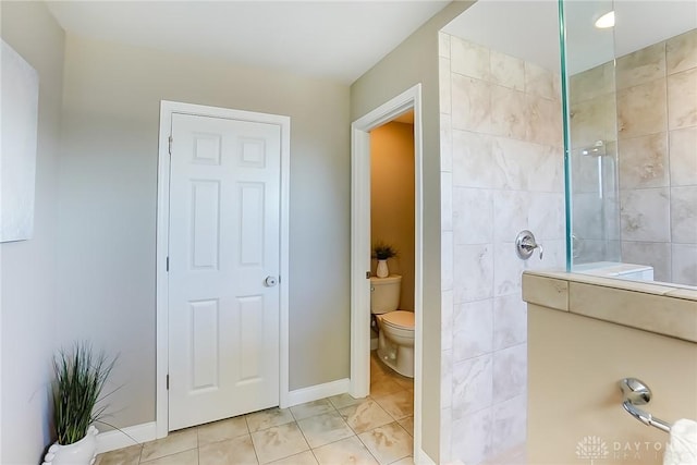 bathroom featuring a tile shower and toilet