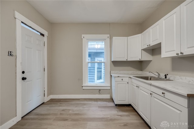 kitchen featuring white cabinetry, light hardwood / wood-style flooring, and sink