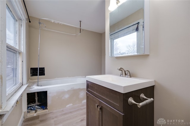 bathroom featuring hardwood / wood-style flooring, vanity, and a bathtub